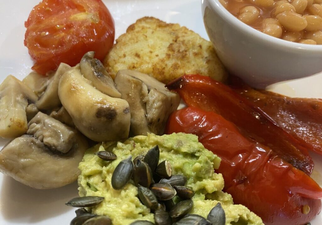 Goodwin Guest House VG Breakfast Smashed avocado with toasted pumpkins seeds roasted red peppers sauteed mushrooms hash brown grilled vine tomato and baked beans
